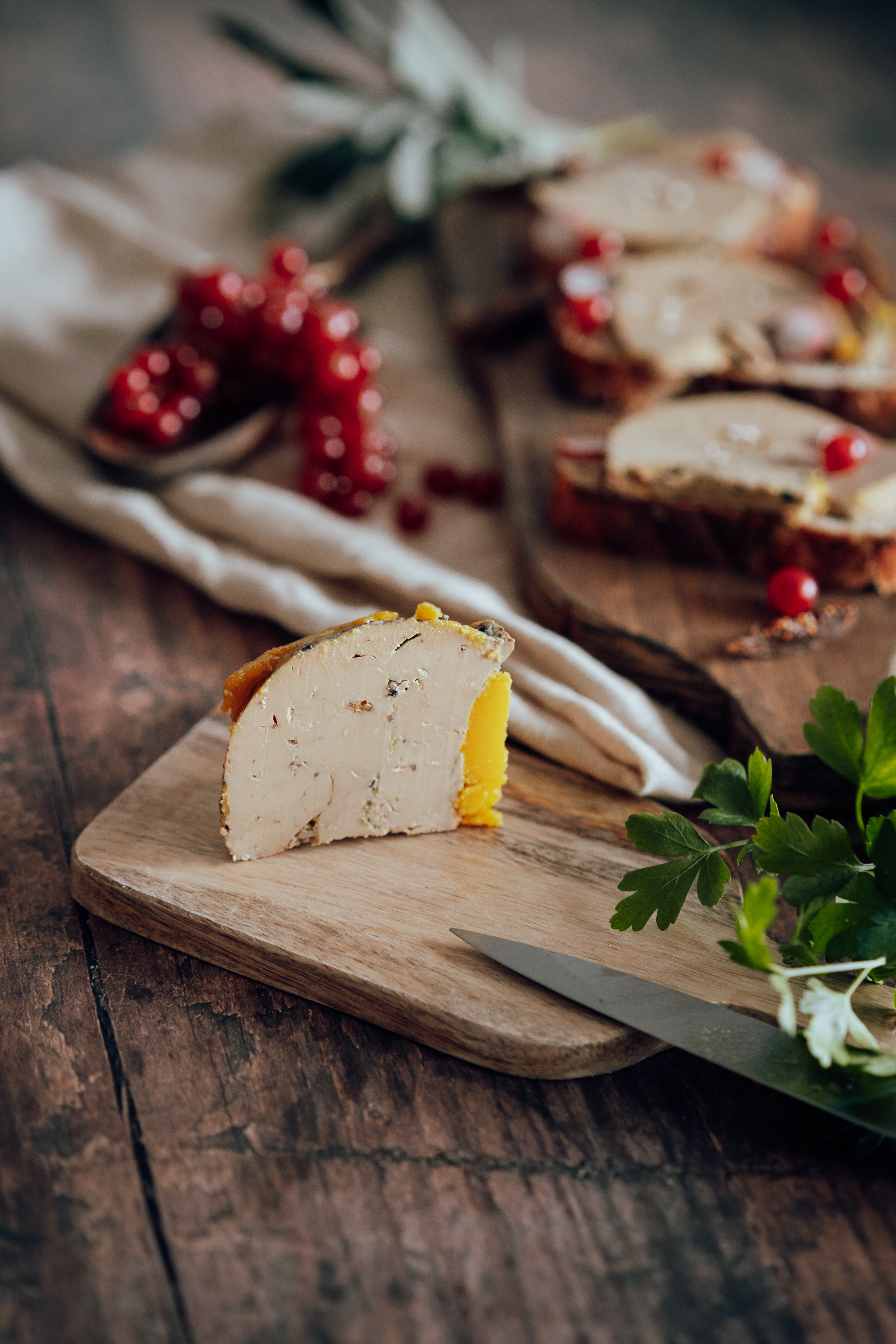 Photo d’une tranche de foie gras découpée avec des toasts en arrière-plan
